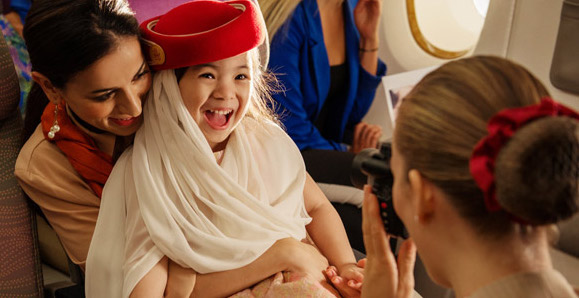 Young Emirates passenger with cabin crew